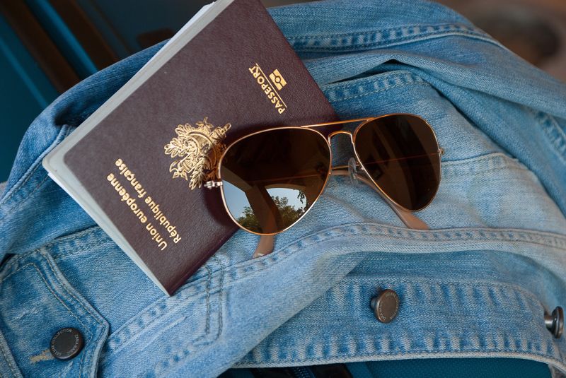 Sunglasses and passport on top of jacket